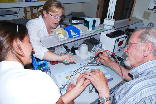 Dr Lemay enseignant la soudure pour fabriquer un appareil orthodontique aux techniciennes de laboratoire.